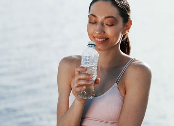 A promotional visual for The Sentral IVs Solution showcases a fit woman who has recovered from Bali Belly, now happy and enjoying her Bali holiday.