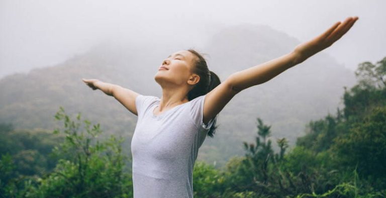 A visual of an Asian woman breathing fresh air in spring forests, conveying the message of 'Improving Your Lung Health with Sentral IVs