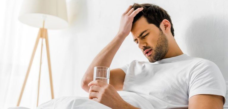 A photograph of a man experiencing a hangover and receiving hangover treatment from Sentral IVs in the comfort of his villa, including his cozy bed and medical equipment, represents 'Sentral IVs - Your Hangover Solution.