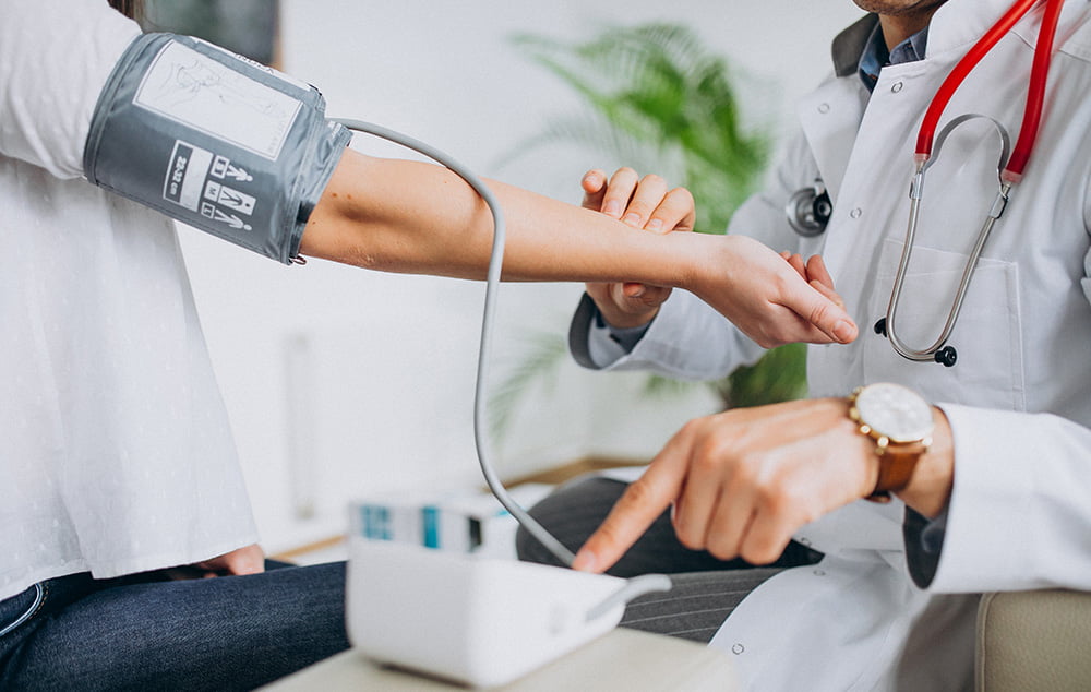 young-male-psysician-with-patient-measuring-blood-pressure