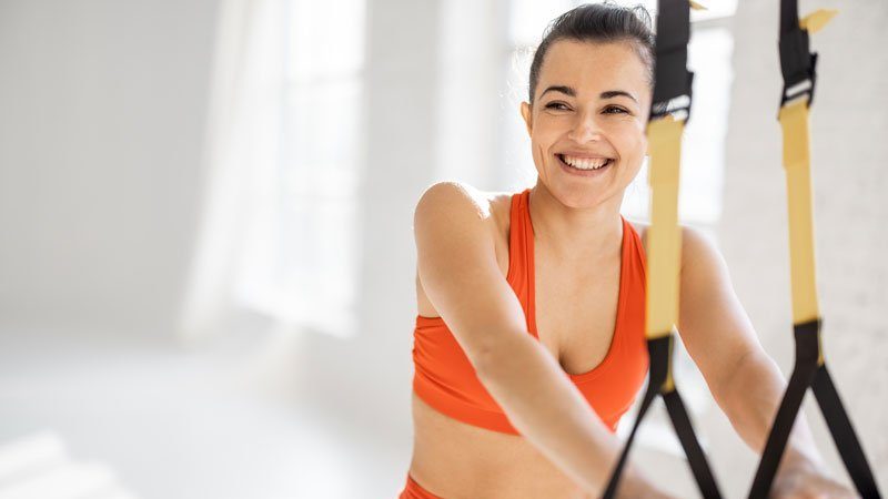 A visual of a vibrant professional training on TRX fitness straps, highlighting the potential to 'Unlock Your Peak Performance with Sentral IVs